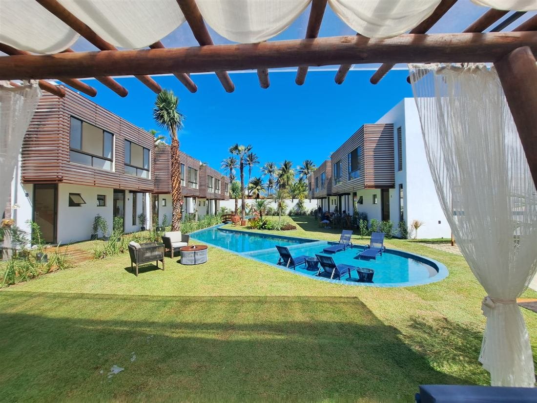 Área de lazer com piscina, pergolado e jardim entre edifícios